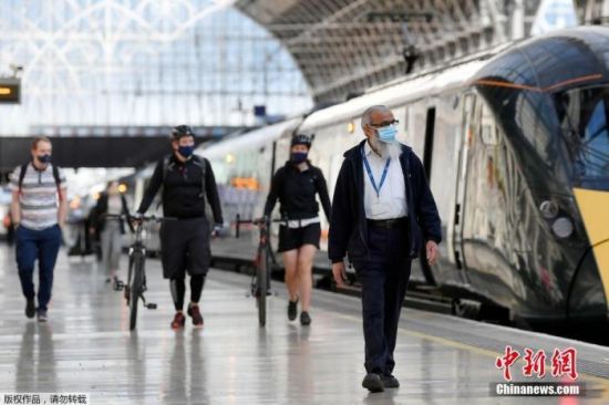当地时间6月15日，英国伦敦，戴着口罩的通勤者到达帕丁顿车站。