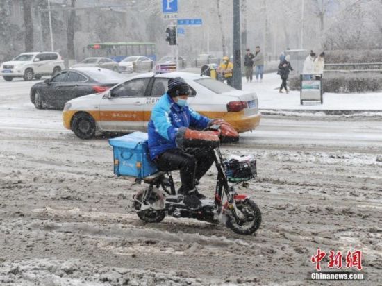 资料图：外卖小哥冒雪送餐。 中新社记者 刘栋 摄