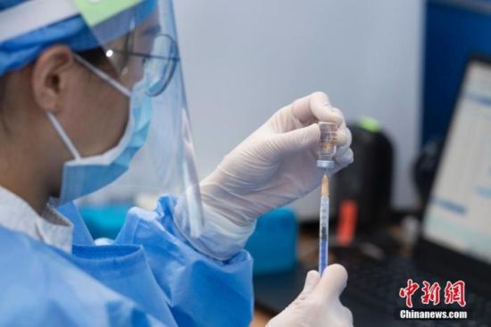 4月27日，广州市天河体育中心新冠疫苗临时接种点的工作人员为疫苗接种做准备。中新社记者 陈楚红 摄