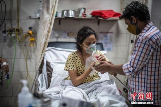 资料图：当地时间2021年5月6日，印度新德里，在圣家医院的ICU病房照料新冠肺炎患者。 图片来源：视觉中国