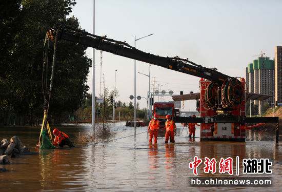 7月31日，在郑州中牟一路段，湖北咸宁消防指战员正在进行排涝作业。王方 摄