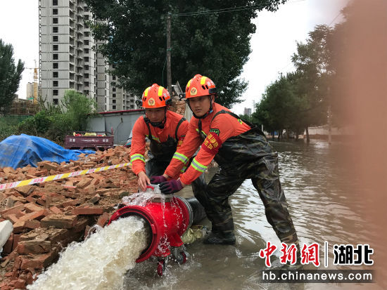 7月29日，在郑州市中牟县白沙镇，湖北宜昌消防指战员对排涝出水口进行监测。曹世龙 摄
