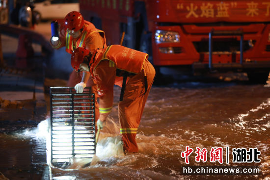 7月26日，在郑州市中牟县商都大道一住宅区旁，湖北荆州消防指战员进行排涝作业。王方 摄