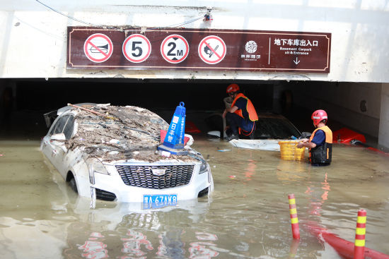 7月25日，在郑州中牟一小区，湖北武汉消防指战员进行排涝作业。王方摄