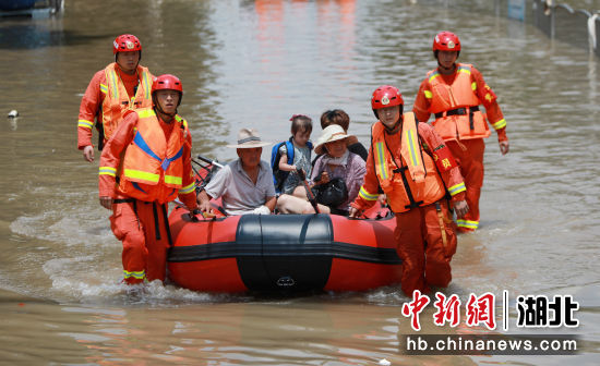 7月24日，在郑州市中牟县白沙镇，湖北孝感消防救援人员运送受困群众。王方 摄