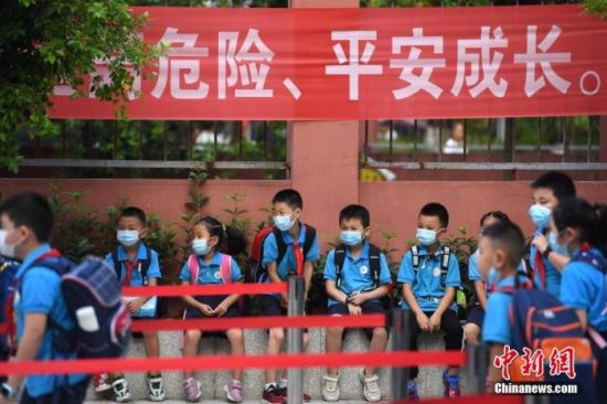 资料图：2020年9月1日，重庆市大渡口区双山实验小学的学生们戴着口罩有序进入校园。 中新社记者 陈超 摄