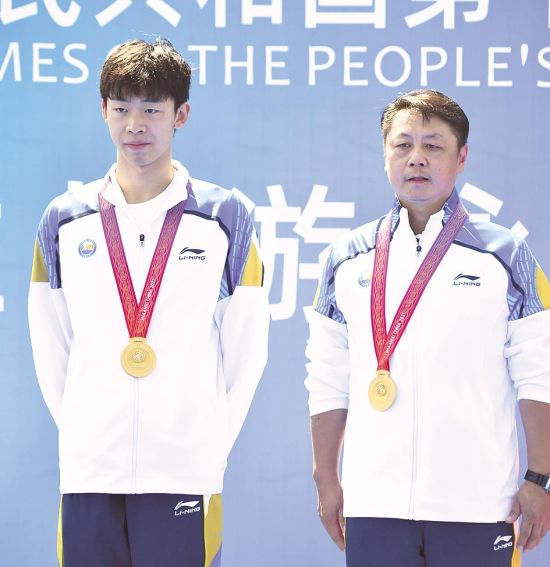 9月13日，湖北队选手张子扬(左)与教练员成章在颁奖仪式上。 (新华社发)