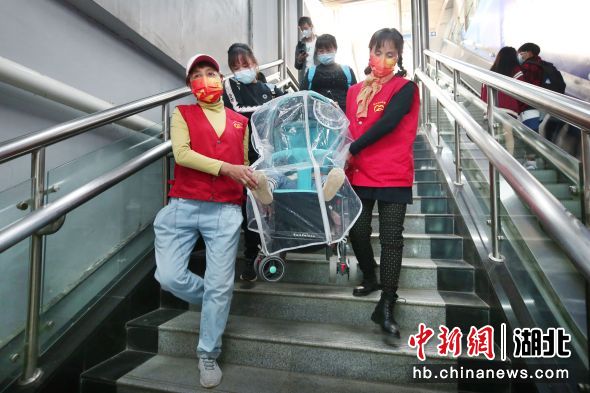 武汉地铁循礼门站志愿者为乘客搬送婴儿车