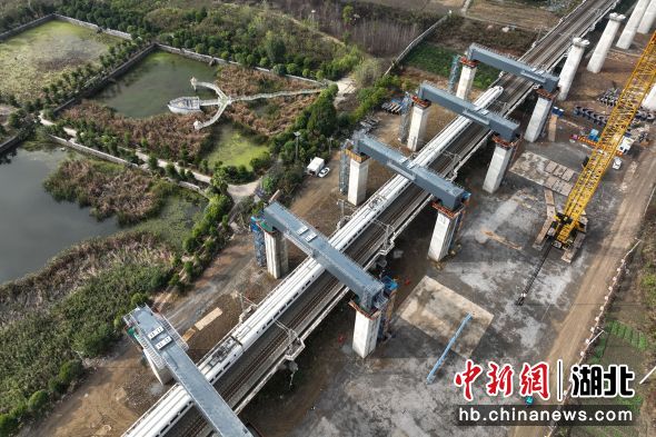 11月22日，一列高铁列车经过完成吊装后的钢盖梁(无人机照片)。雷佳民摄