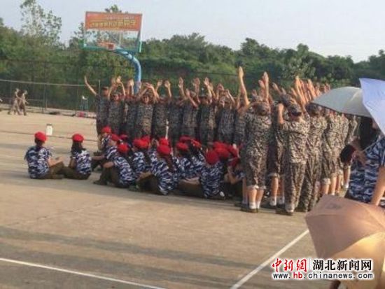 湖北新闻网 图:男生军训场上高举双手为女生挡